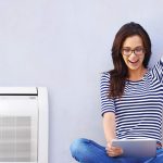 Girl with her hand up looking at a computer screen