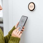 Woman programming a thermostat